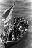 35 Vietnamese refugees wait to be taken aboard the amphibious command ship USS Blue Ridge. They are being rescued from a 35 foot fishing boat 350 miles northeast of Cam Ranh Bay, Vietnam, after spending eight days at sea.<br/><br/>

Boat people is a term that usually refers to refugees or asylum seekers who emigrate in numbers in boats that are sometimes old and crudely made. The term came into common use during the late 1970s with the mass departure of Vietnamese refugees from Communist-controlled Vietnam, following the Vietnam War. Many Vietnamese boat people - though not all - came from the south, the former Republic of Vietnam; also, many were Hoa or ethnic Chinese.